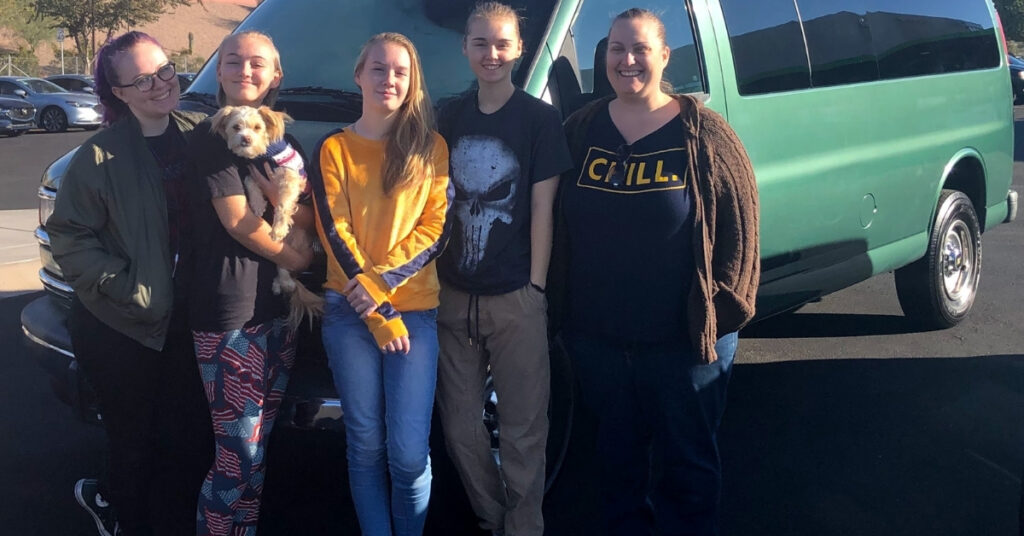 Four teenagers, their middle aged mom and the cutest dog in the world standing in front of a green cargo van